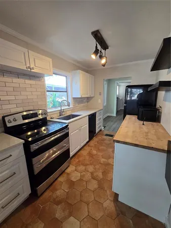 a kitchen with stainless steel appliances a sink a stove and a window