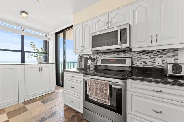 a kitchen with stainless steel appliances granite countertop a stove microwave and cabinets