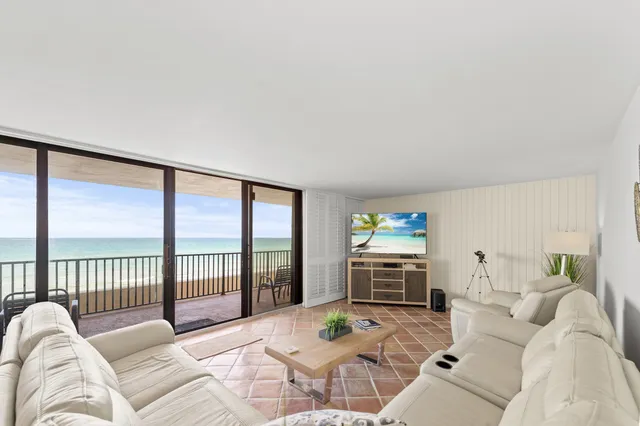 a living room with furniture a flat screen tv and a large window