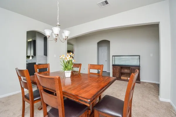 a dining room with furniture a chandelier and wooden floor
