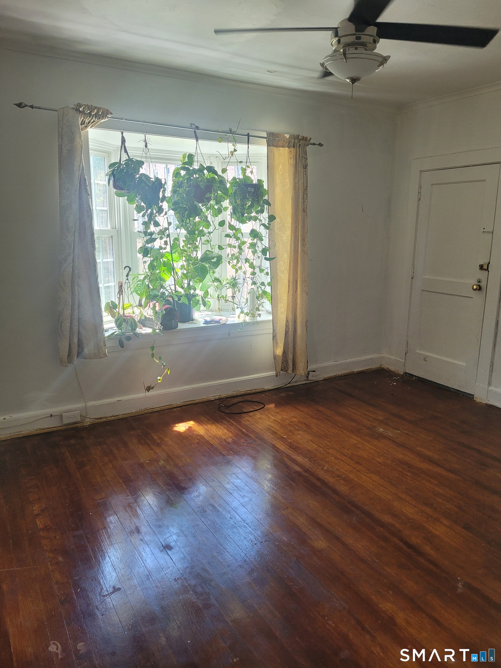 606 Wilmot Avenue, Unit 4 Bridgeport, CT 06607 - Photo 5 of 16 an empty room with wooden floor and windows