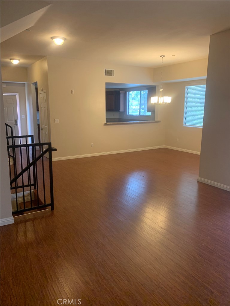 920 Central Avenue, Unit 101 Riverside, CA 92507 - Photo 11 of 23 an empty room with wooden floor and windows