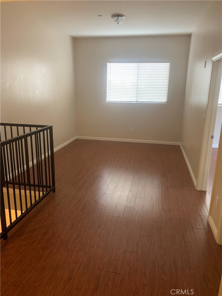 920 Central Avenue, Unit 101 Riverside, CA 92507 - Photo 14 of 23 an empty room with wooden floor and windows