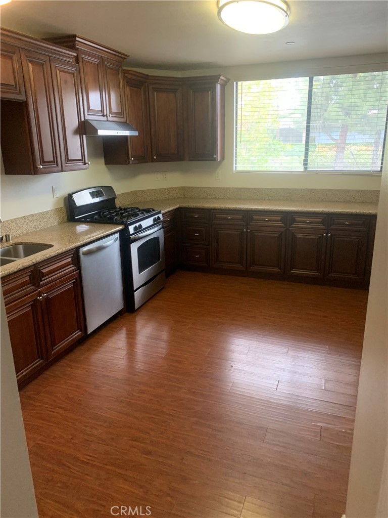 920 Central Avenue, Unit 101 Riverside, CA 92507 - Photo 5 of 23 a kitchen with granite countertop a stove a sink and a window