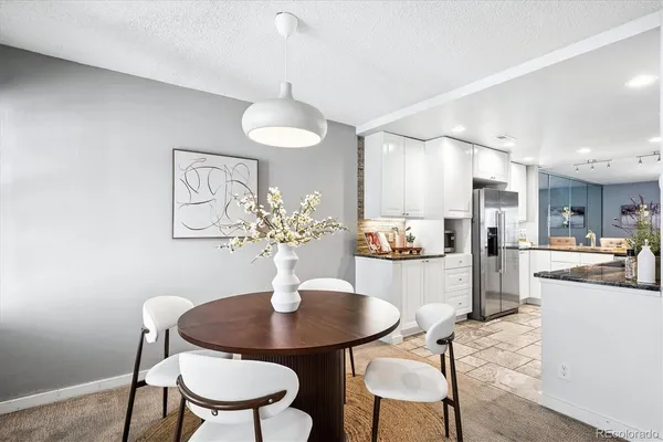 a kitchen with a dining table cabinets and chairs
