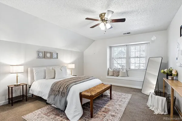 a bed room with a bed a couch and a window