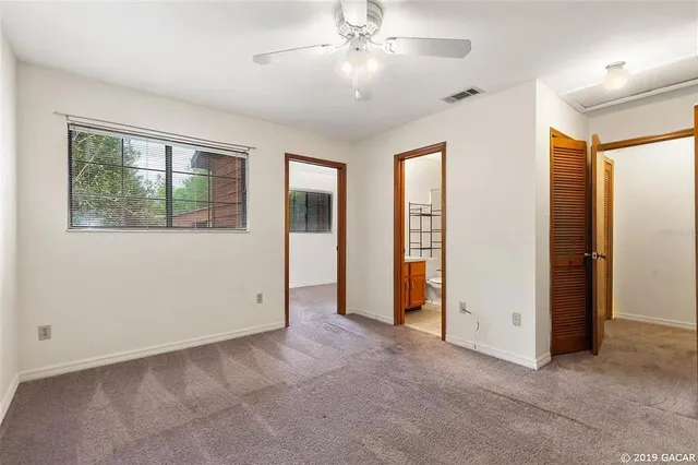an empty room with windows and closet