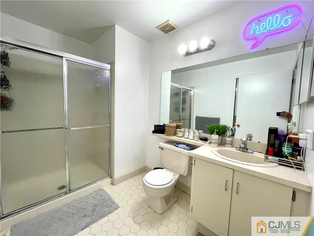 341 Wimbeldon Court North Brunswick, NJ 08902 - Photo 11 of 16 a bathroom with a granite countertop sink toilet a mirror and shower