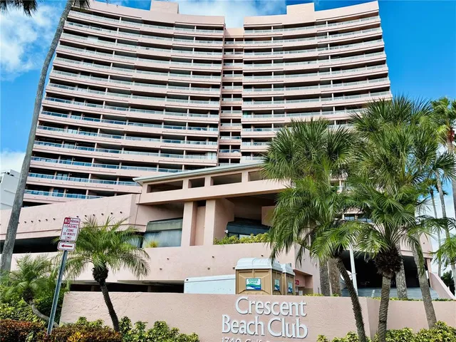 a front view of a building with a garden and plants