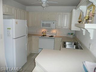 519 Roma Court, Unit 207 Naples, FL 34110 - Photo 3 of 8 a kitchen with stainless steel appliances a refrigerator sink and cabinets