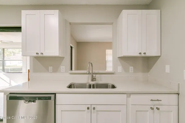 a kitchen with stainless steel appliances granite countertop white cabinets and a sink