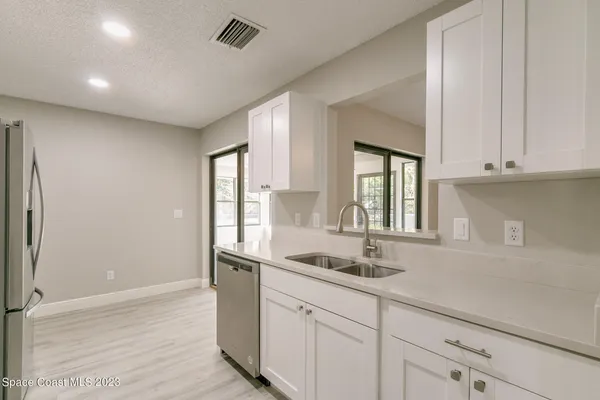 a kitchen with granite countertop white cabinets and a sink