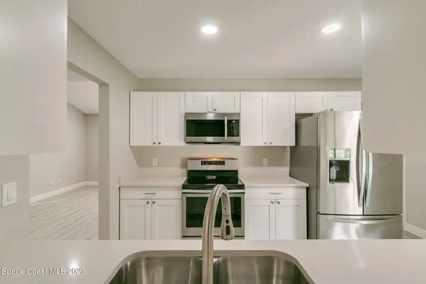 a kitchen with stainless steel appliances granite countertop a refrigerator and a stove top oven