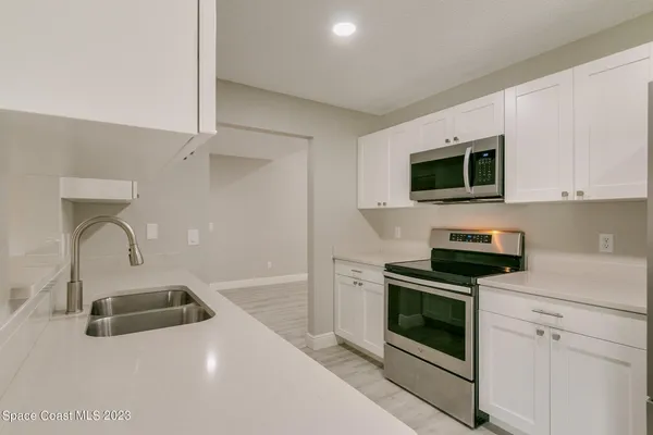 a kitchen with a sink a stove and microwave