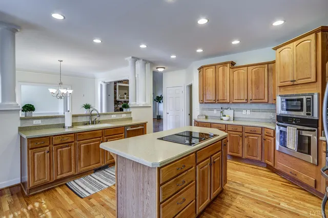 a kitchen with stainless steel appliances granite countertop a sink a stove and a wooden floors