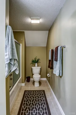 a view of a house with a small yard and a large tree