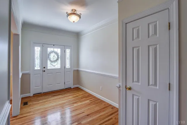 a view of a dining room with wooden floor and a window