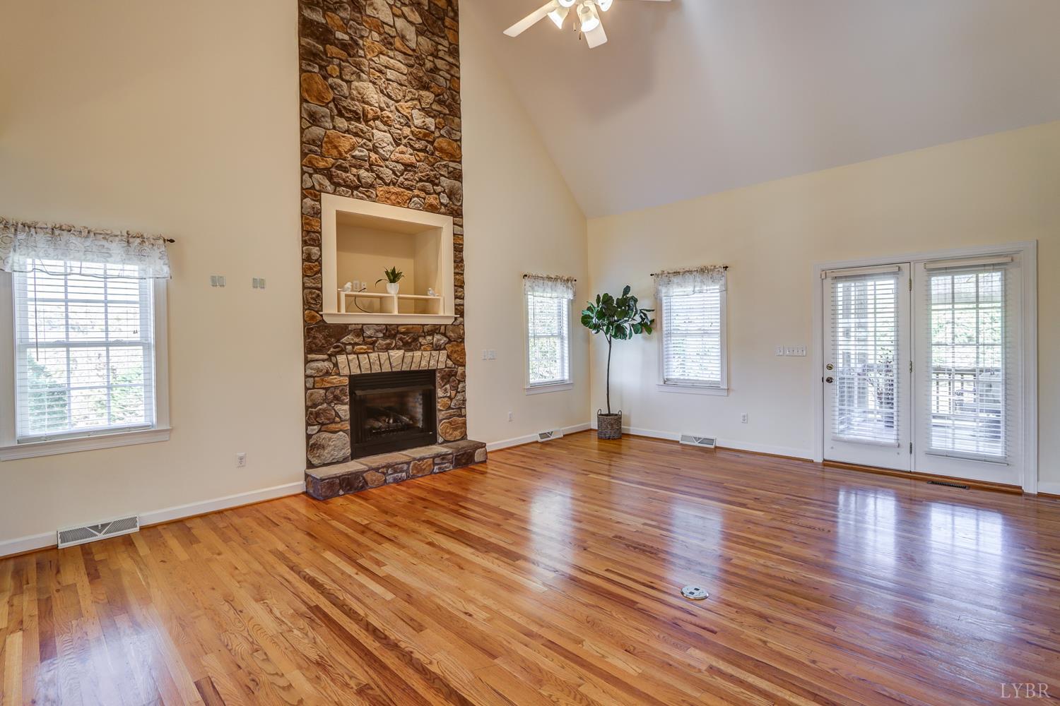 1315 Donnally Road Forest, VA 24551 - Photo 9 of 74 an empty room with wooden floor fireplace and windows