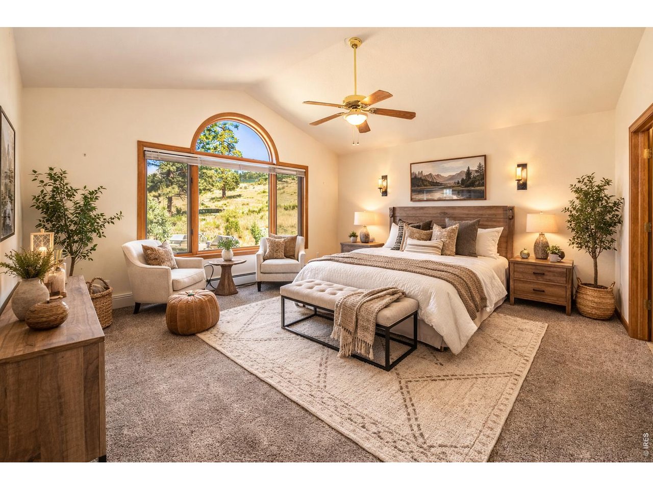 683 Cedar Ridge Circle Estes Park, CO 80517 - Photo 18 of 39 a spacious bedroom with a bed a chandelier and a large window
