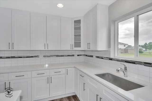 a view with granite countertop white cabinets and a sink