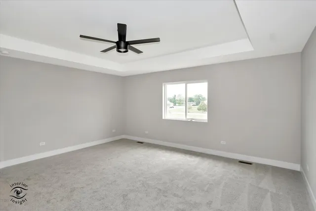 an empty room with a ceiling fan and window