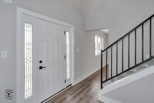 a view of a hallway with wooden floor and staircase