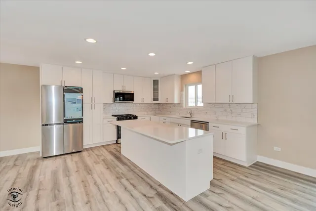 a large kitchen with a sink and refrigerator