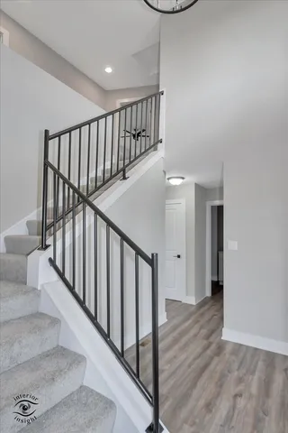 a view of staircase with railing and white walls