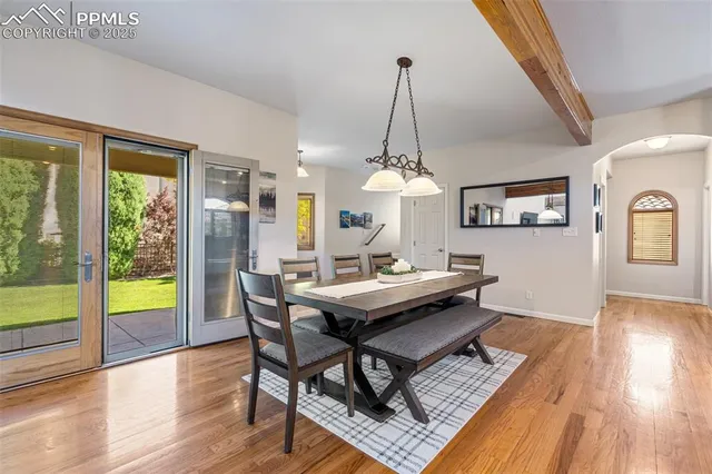 a view of a dining room with furniture a chandelier and wooden floor