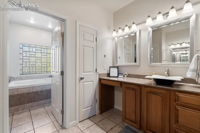 a spacious bathroom with a granite countertop sink a mirror and a bathtub