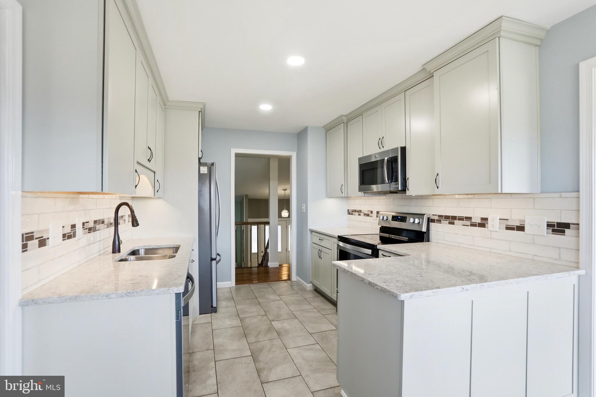 4708 Summit Point Road Charles Town, WV 25414 - Photo 11 of 49 a kitchen with granite countertop a sink a stove top oven and refrigerator