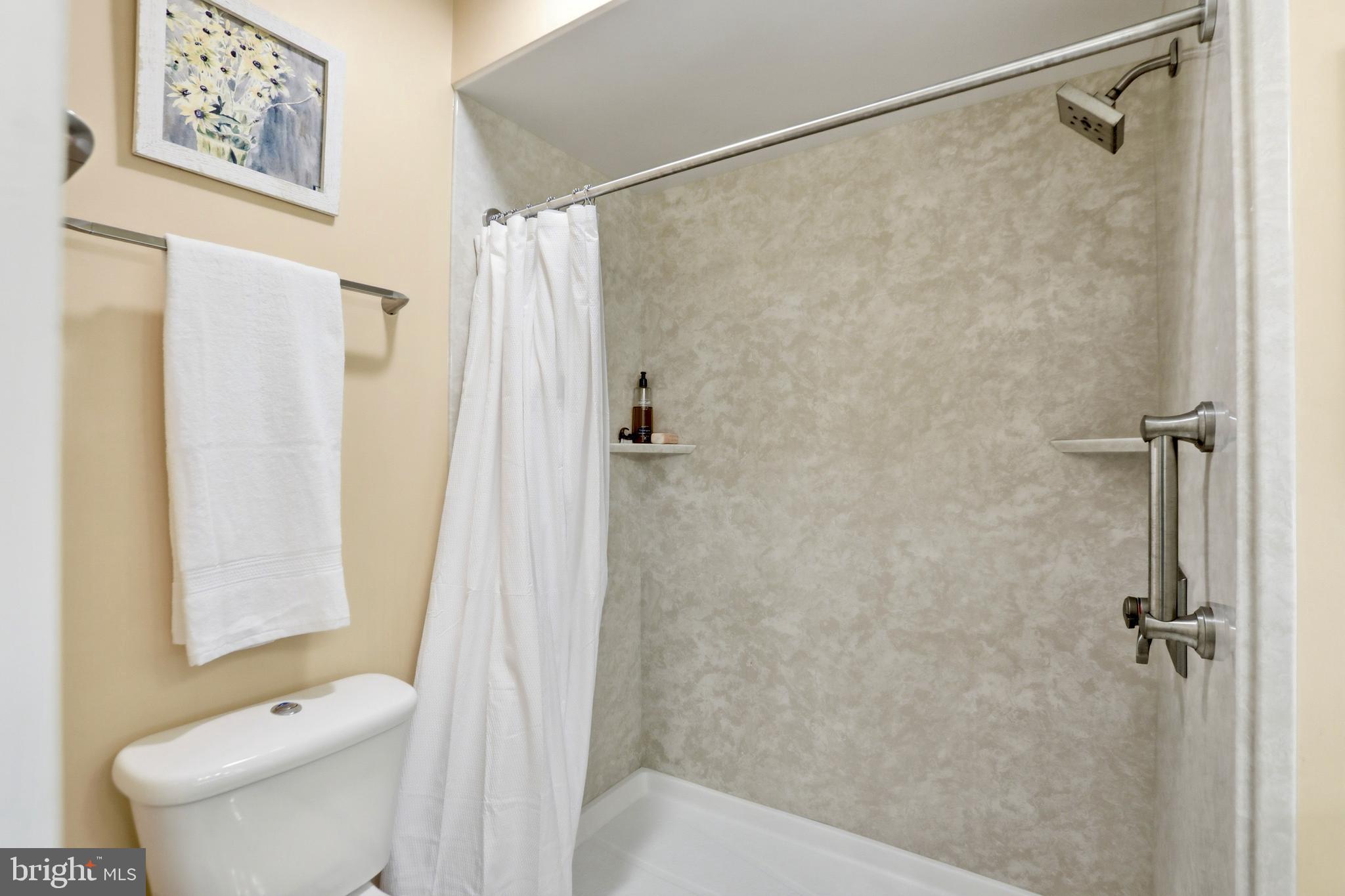 4708 Summit Point Road Charles Town, WV 25414 - Photo 24 of 49 a bathroom with a shower curtain and a toilet