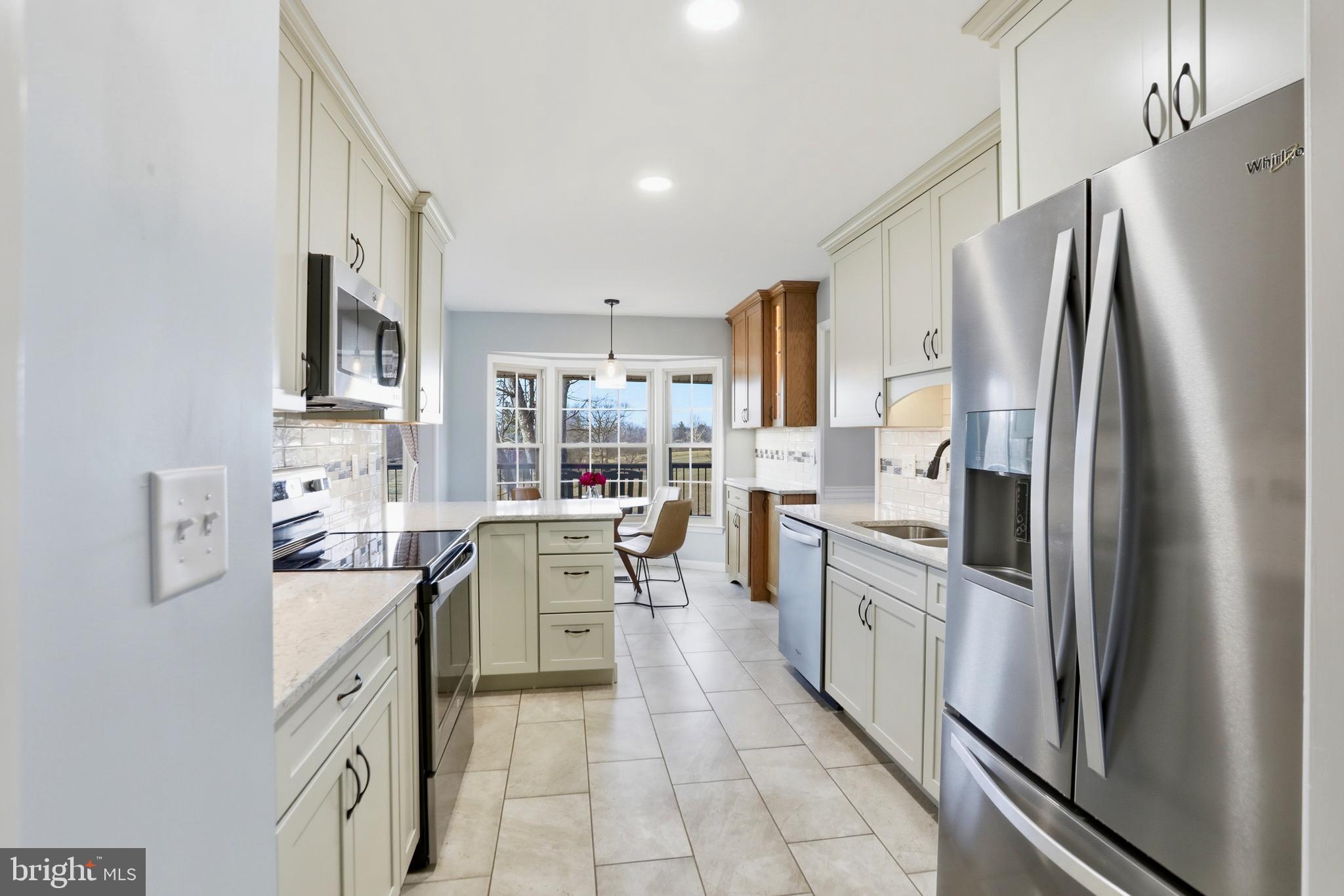 4708 Summit Point Road Charles Town, WV 25414 - Photo 8 of 49 a kitchen with white cabinets and stainless steel appliances