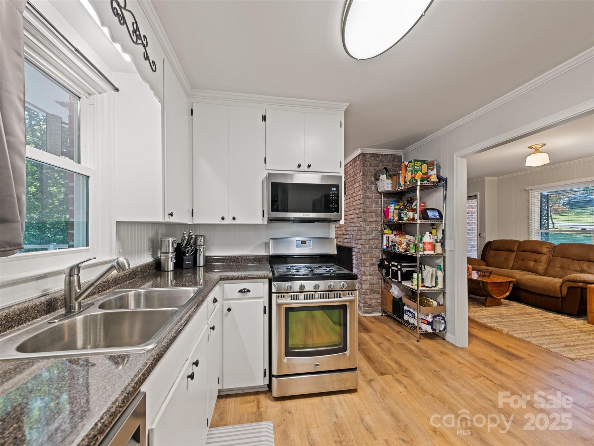 263 Blanton Street Columbus, NC 28722 - Photo 16 of 45 a kitchen with stainless steel appliances granite countertop a sink a stove and a wooden floors
