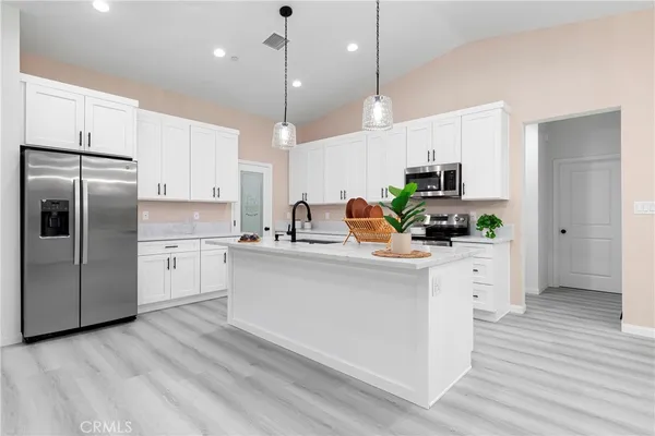 a kitchen with kitchen island white cabinets and white appliances