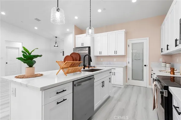 a kitchen with granite countertop a sink a stove and cabinets