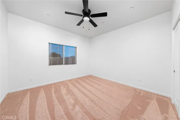 an empty room with a window and a ceiling fan