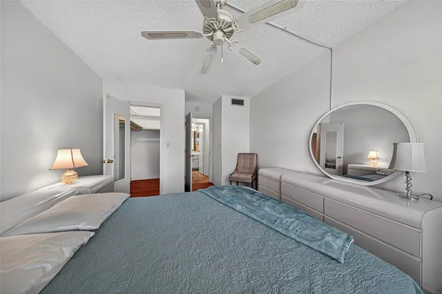 a view of a big house with a big yard and potted plants and large trees