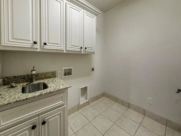 a kitchen with granite countertop white cabinets and sink