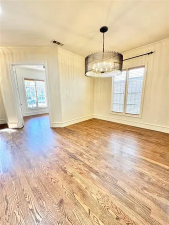 a view of empty room with wooden floor and window
