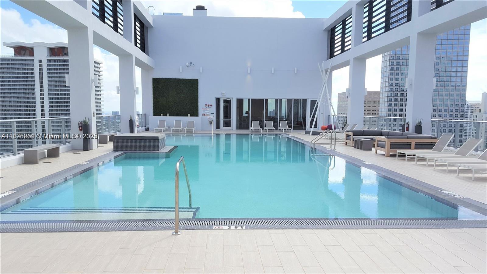 151 Southeast 1st Street, Unit 2807 Miami, FL 33131 - Photo 14 of 24 a kitchen with a refrigerator a sink and a large window