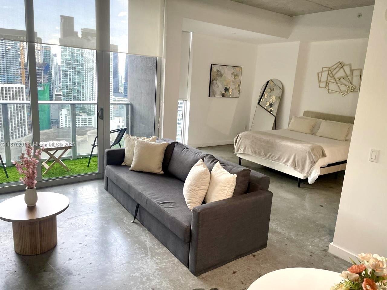 151 Southeast 1st Street, Unit 2807 Miami, FL 33131 - Photo 2 of 24 a living room with furniture and a large window