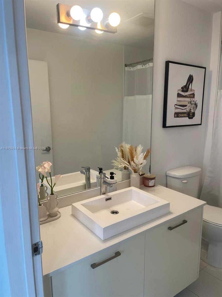 151 Southeast 1st Street, Unit 2807 Miami, FL 33131 - Photo 7 of 24 a bathroom with a sink and a mirror