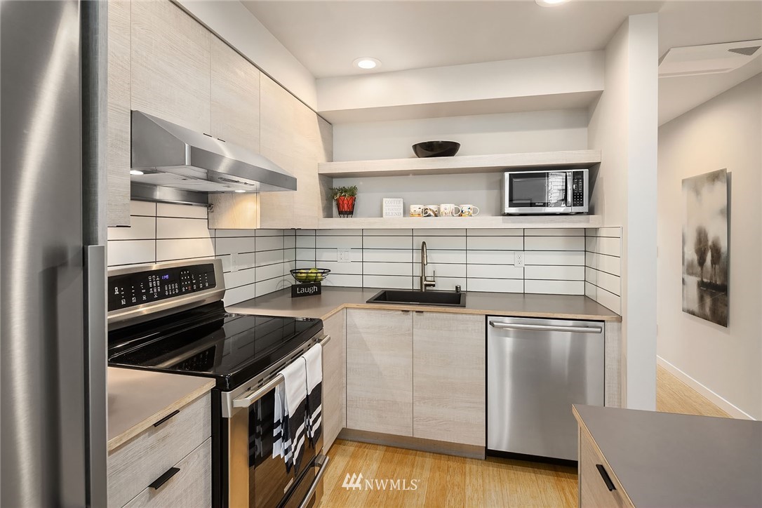 983 North 45th Street Seattle, WA 98103 - Photo 11 of 32 a kitchen with stainless steel appliances a stove and a refrigerator