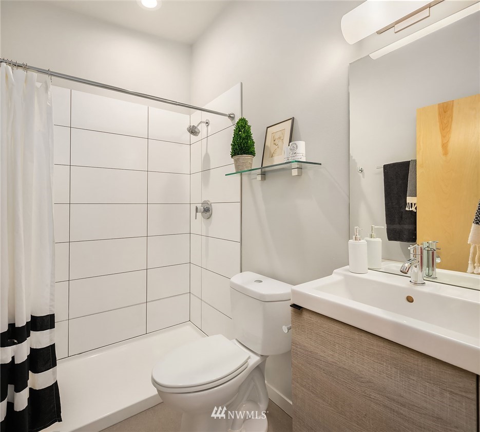 983 North 45th Street Seattle, WA 98103 - Photo 22 of 32 a bathroom with a sink a toilet and shower