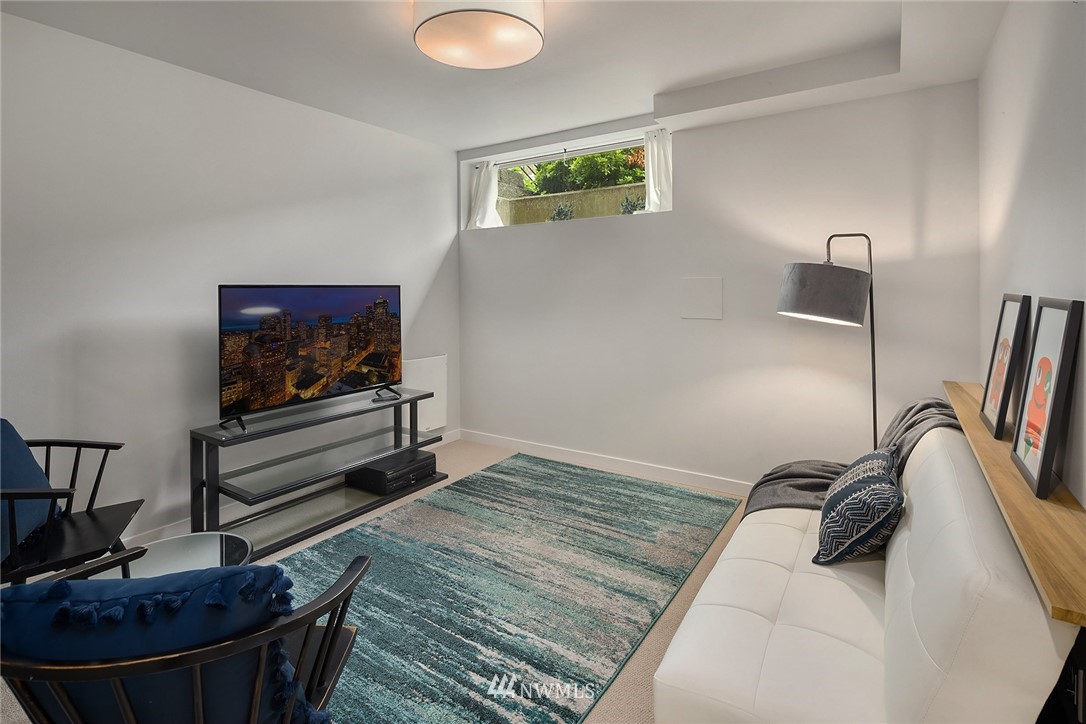 983 North 45th Street Seattle, WA 98103 - Photo 27 of 32 a bedroom with a bed and a flat screen tv