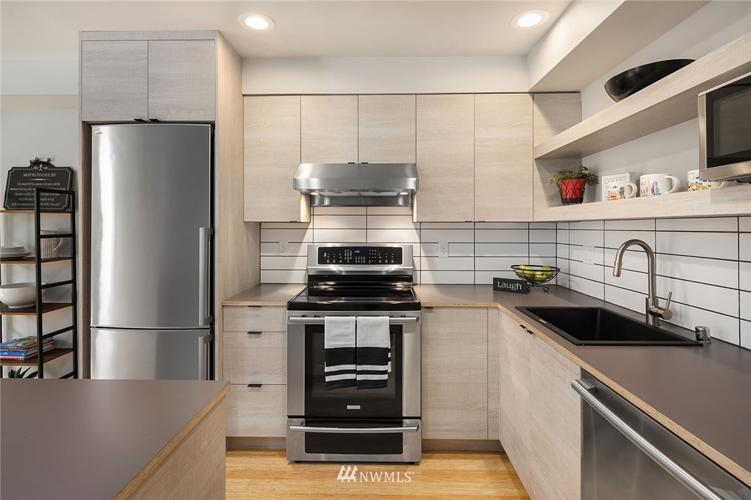 983 North 45th Street Seattle, WA 98103 - Photo 10 of 32 a kitchen with stainless steel appliances a refrigerator and a sink