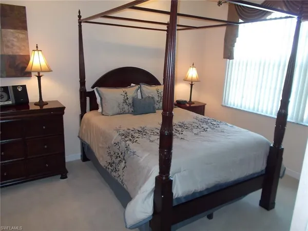 a bedroom with a bed and a lamp