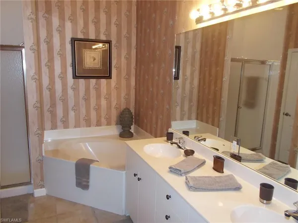 a bathroom with a tub sink and mirror
