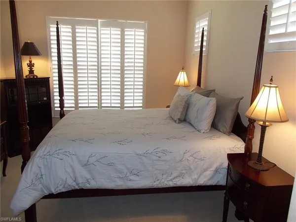 a bedroom with a bed and a lamp